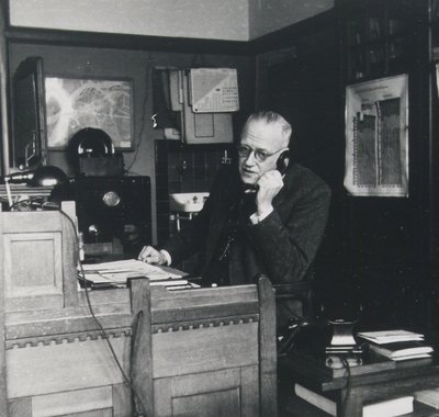 Telefonerende man aan een bureau in een werkruimte.