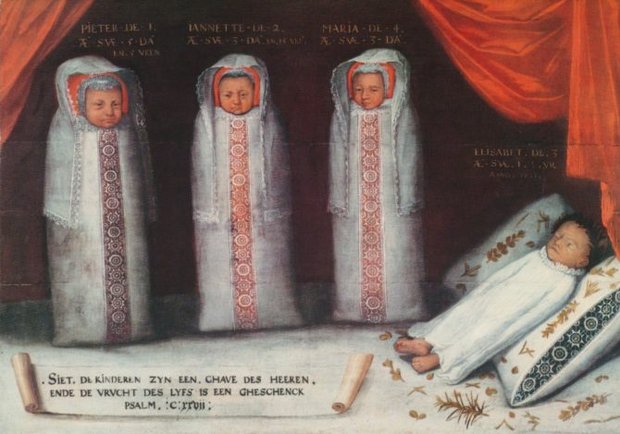 Drie babies staan rechtop ingebakerd, een overleden baby ligt horizontaal op een kussen.