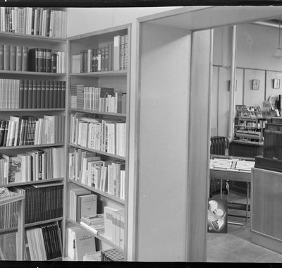 Een kantoor met een uitpuilende boekenkast.