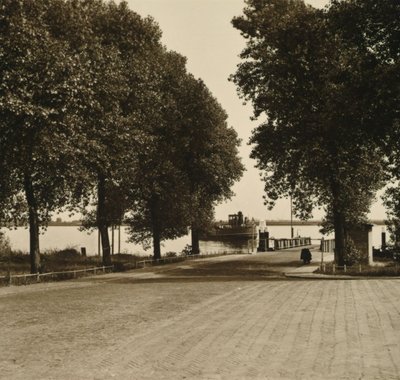 Brede straat die leidt naar de veersteiger. De pont komt eraan.