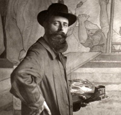 Reinier Kennedy met palet en penselen in de linkerhand, poserende voor zijn tweede wandschildering.