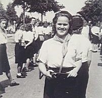 Dordtse verzetsstrijder Leni Dicke staat in uniform te midden van andere dames breed lachend in de zon.