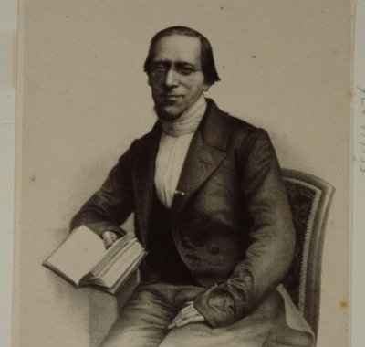 Portret van Gillis Dionysius Jacobus Schotel, zittend met boek in de hand, op 52-jarige leeftijd.