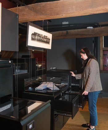 Een persoon kijkt naar de tentoonstelling Dordtenaren in rampspoed.