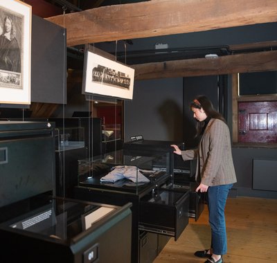Een persoon kijkt naar de tentoonstelling Dordtenaren in rampspoed.