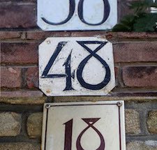 3 huisnummerbordjes boven elkaar: 38, 48, 18.